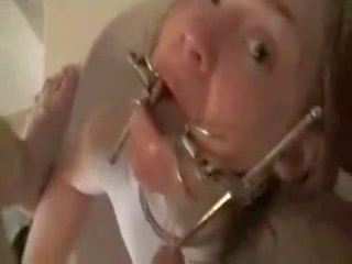 Blonde with a mouth clamp forced to gag